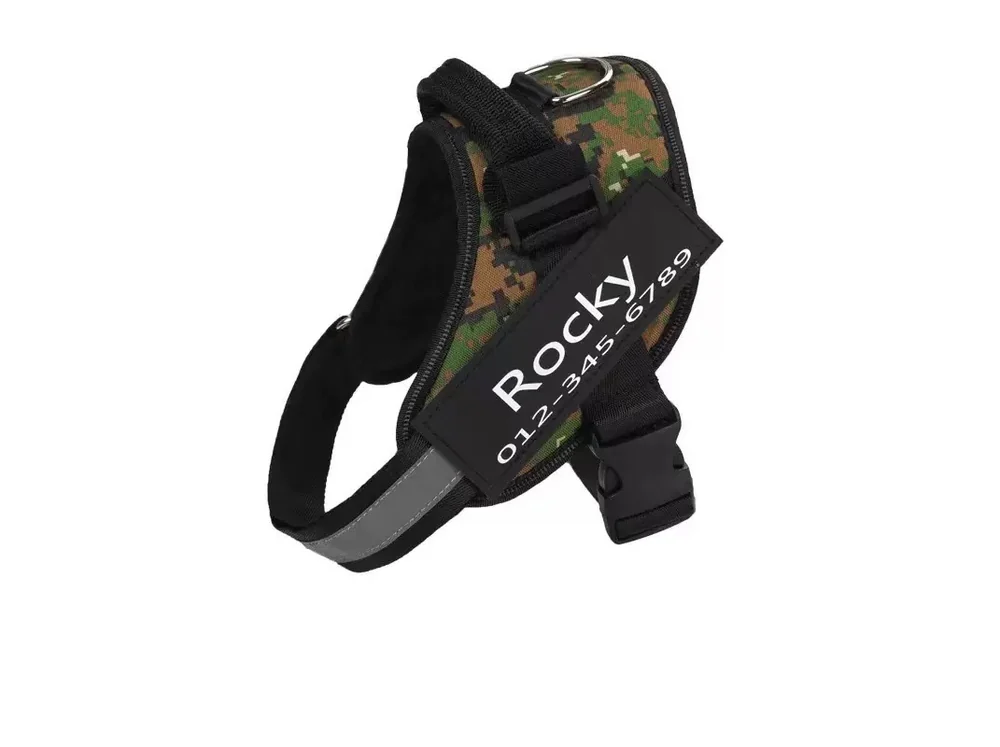 Green camouflage harness with a black name patch and a padded handle, laid flat