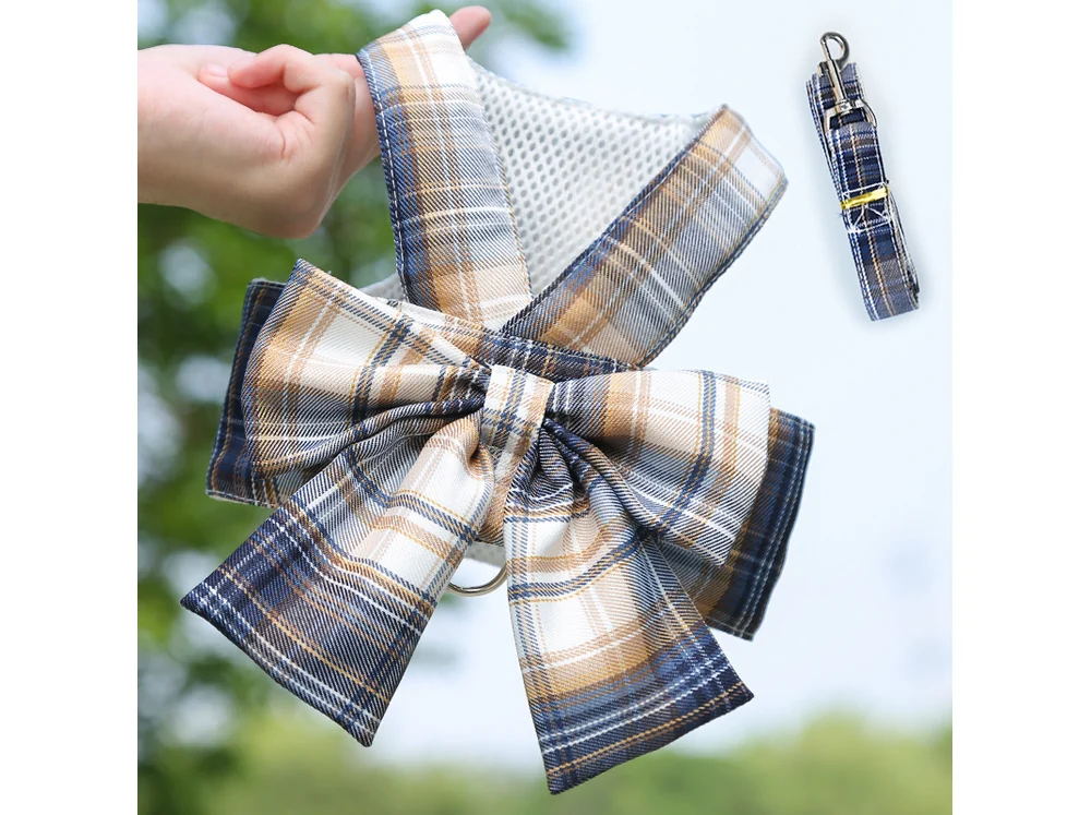 Navy plaid harness with a large bow on the chest and a matching leash, laid flat