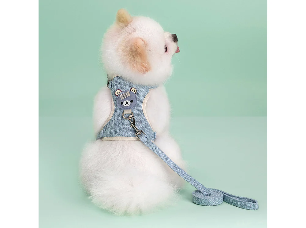 Light blue knitted vest harness with a bear patch and a matching leash, laid flat